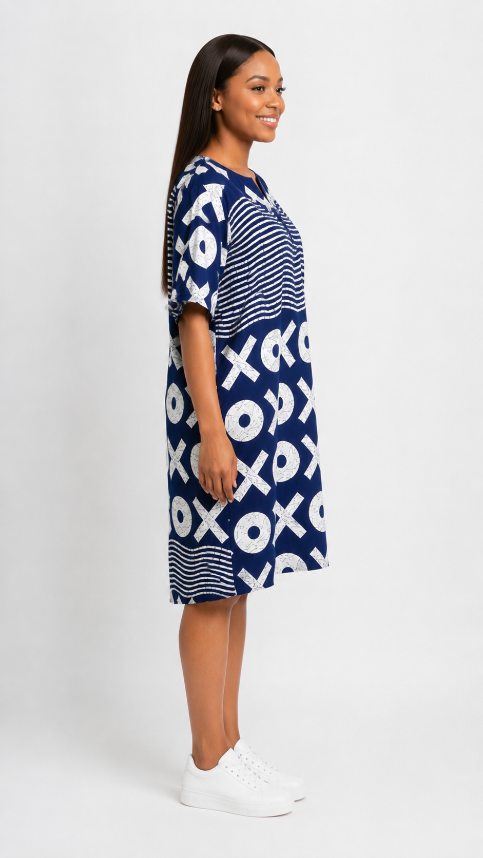 Woman wearing a blue dress with white pattern on a white background