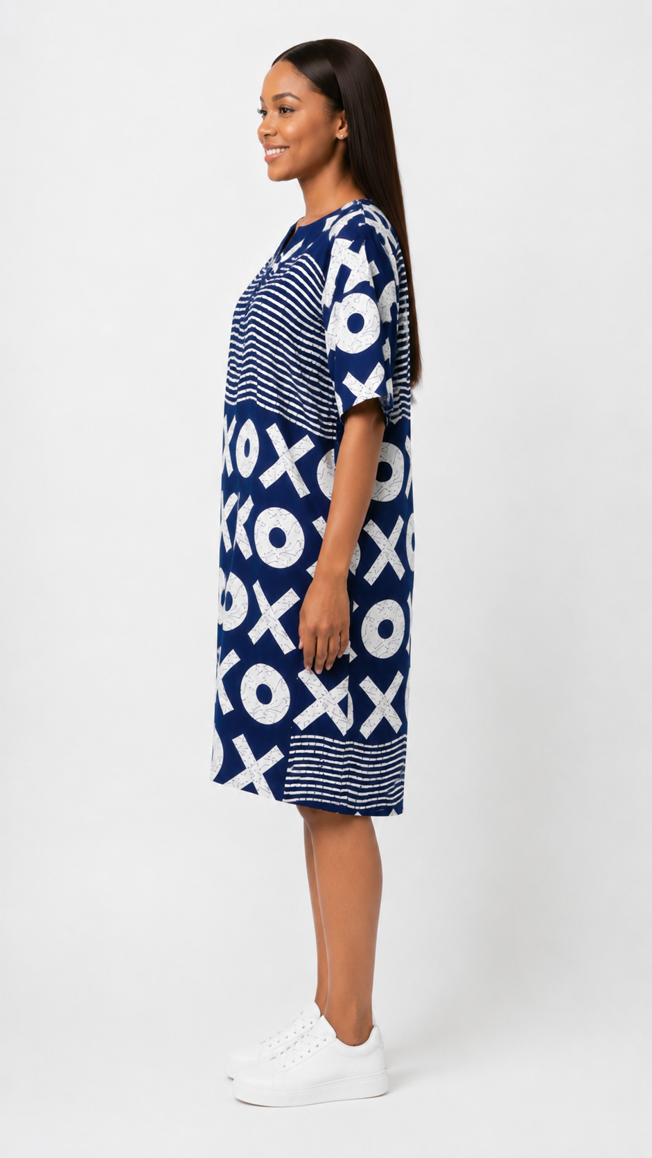 Woman wearing a blue dress with white XO pattern on a white background