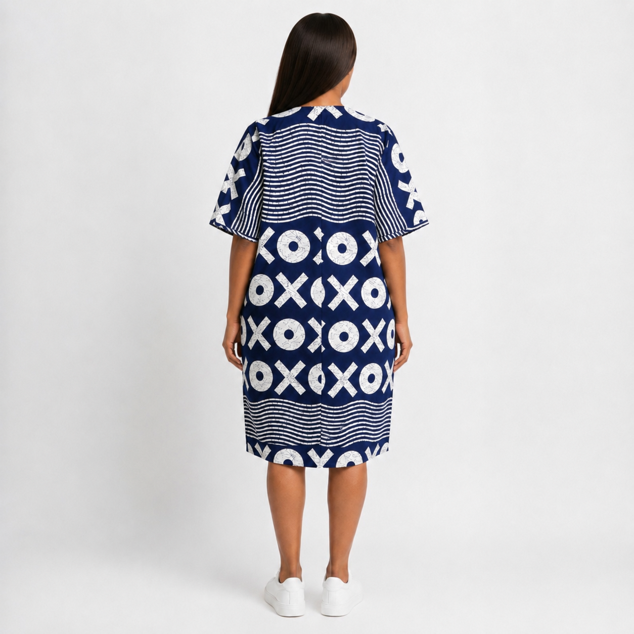 Woman wearing a blue and white patterned dress on a white background